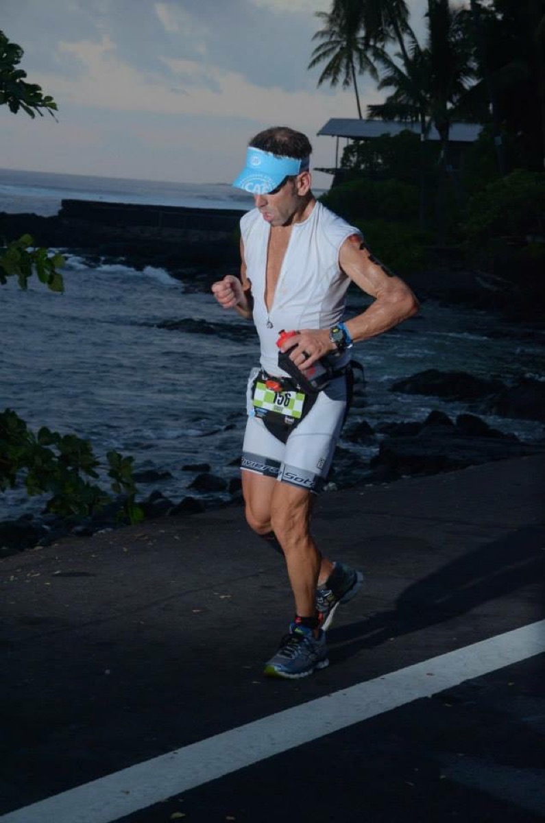 Casey Kammel on the run leg at Kona in a Challenged Athletes Foundation visor, the Pacific behind him